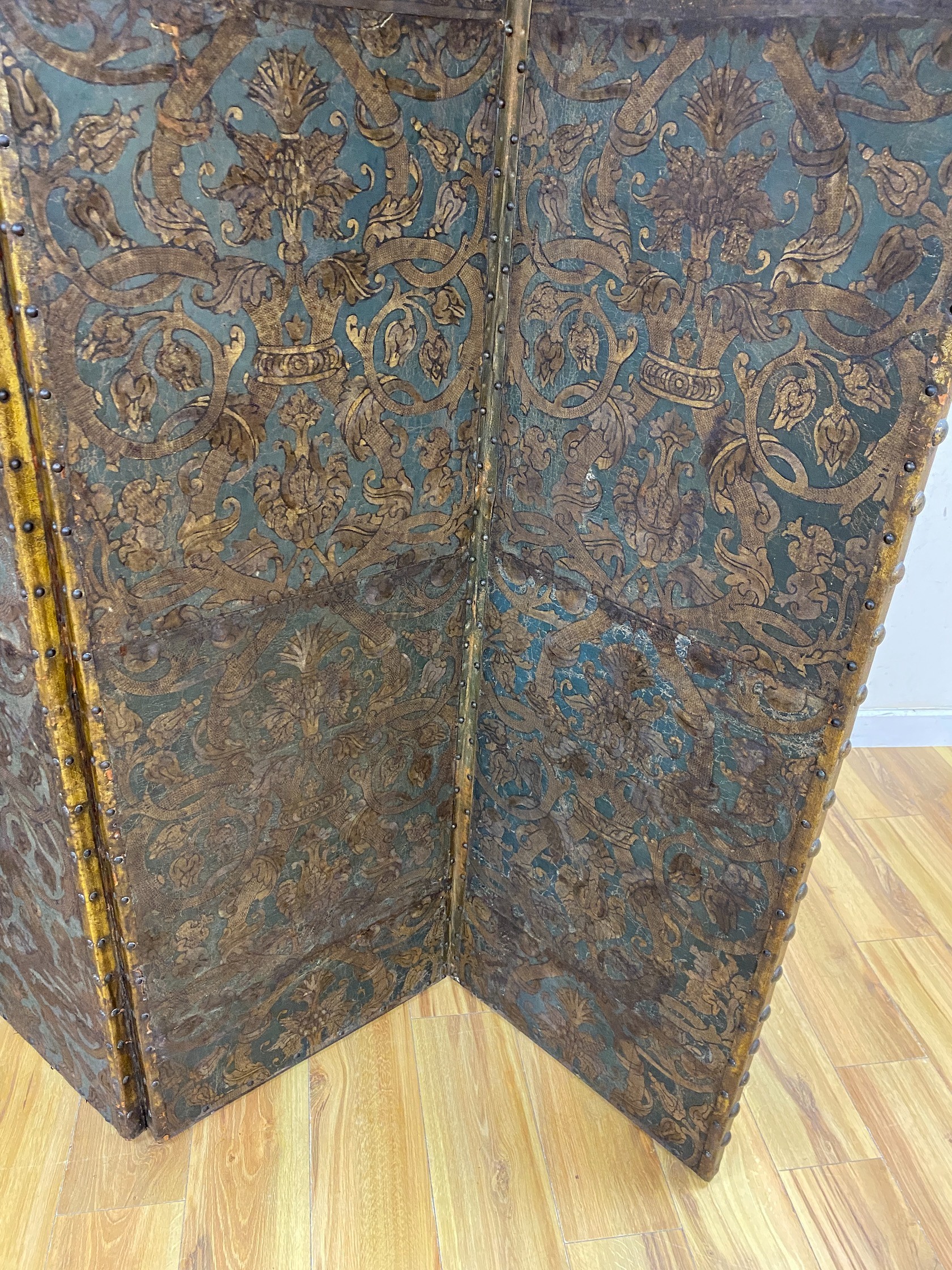 A 19th century French studded leather four fold screen, each panel width 49cm, height 182cm
